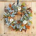 Herbstkranz mit Ahornblättern und Kürbissen für die Haustür